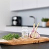 Bouteille de Forever Garlic-Thyme avec ail et thym sur une planche à découper