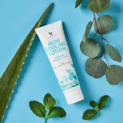 Tube d'Aloe Cooling Lotion Forever Living avec Aloe Vera et menthol, posé à côté de feuilles de menthe et d'eucalyptus